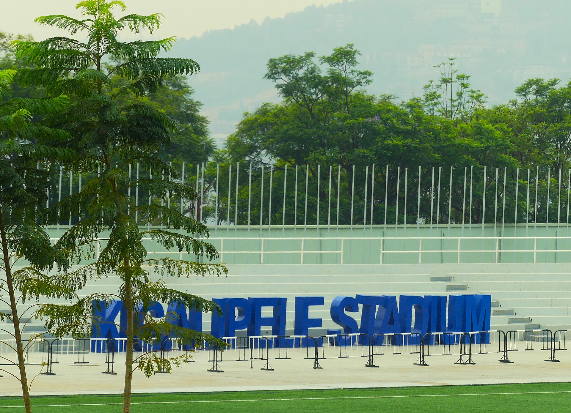 Empty stands and the blue Kigali Pelé Stadium sign at Kigali Pelé Stadium, Kigali, Rwanda, October 1, 2024